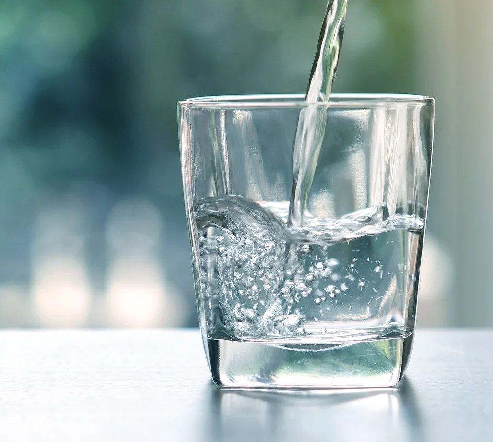Close-up of clean drinking water being poured into a glass.