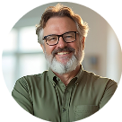 Headshot of an older man with white hair, black glasses, and a green button-up shirt.